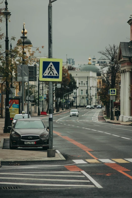 a car driving down a street next to a tall building, a poster, by Julia Pishtar, unsplash, ground level view of soviet town, traffic signs, 000 — википедия, square