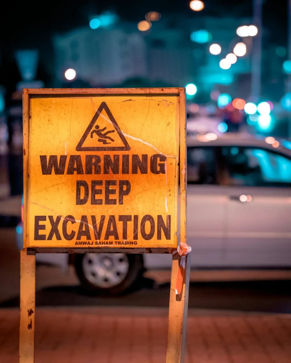 a yellow warning sign sitting on the side of a road, a poster, trending on pexels, deep cave, digging, thick neon lights, dredged seabed