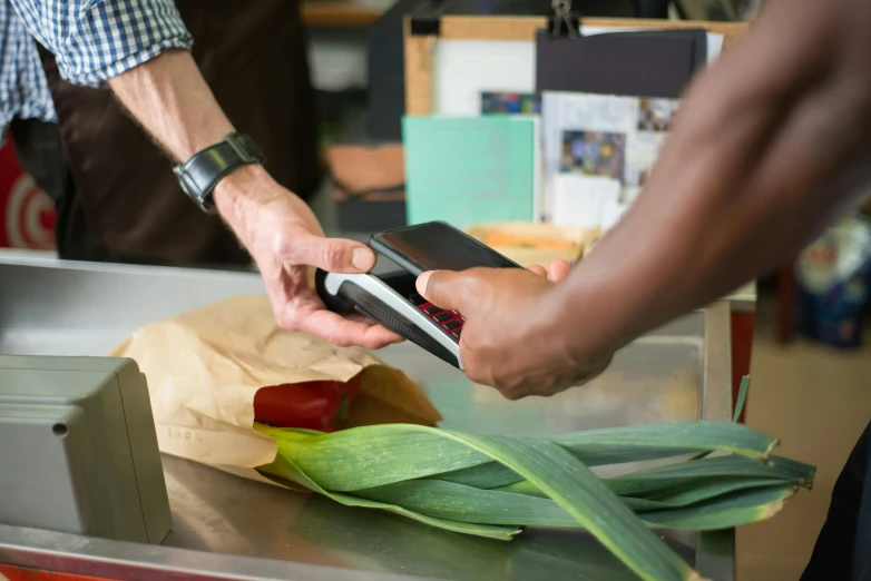 a close up of a person using a cell phone, at checkout, at the counter, holding an epée, ben nicholas