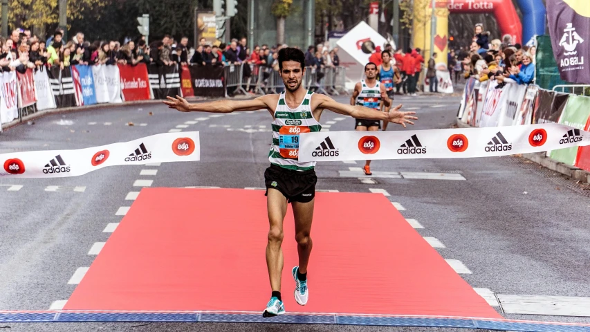 a man crosses the finish line of a marathon, by Matija Jama, pexels contest winner, athletic tall handsome guys, square, diego fernandez, full - length photo