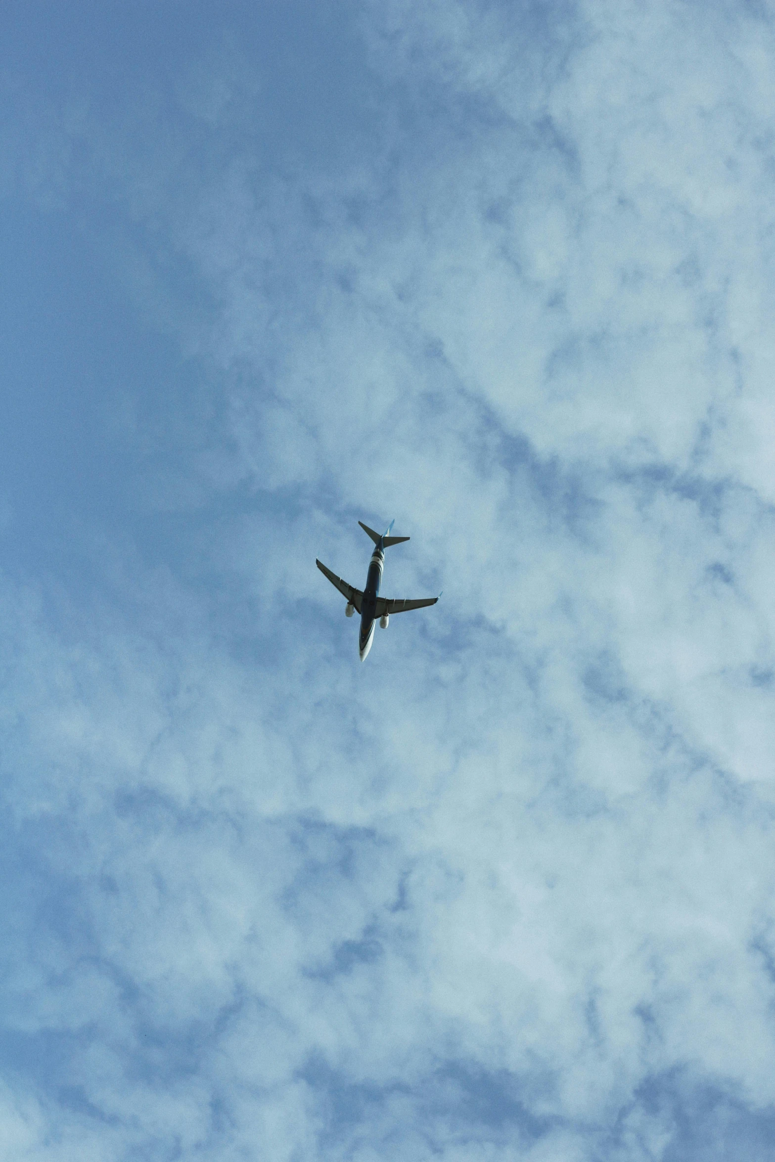 a large jetliner flying through a cloudy blue sky, a picture, by Carey Morris, unsplash, show from below, sighting, video