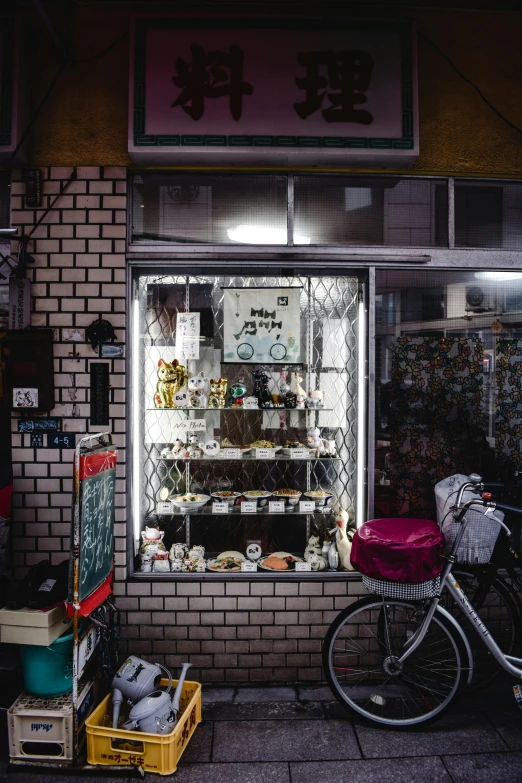 a bicycle parked in front of a store, a picture, unsplash, mingei, inside an old magical sweet shop, night tokyo metropoly, knick - knacks, bakery