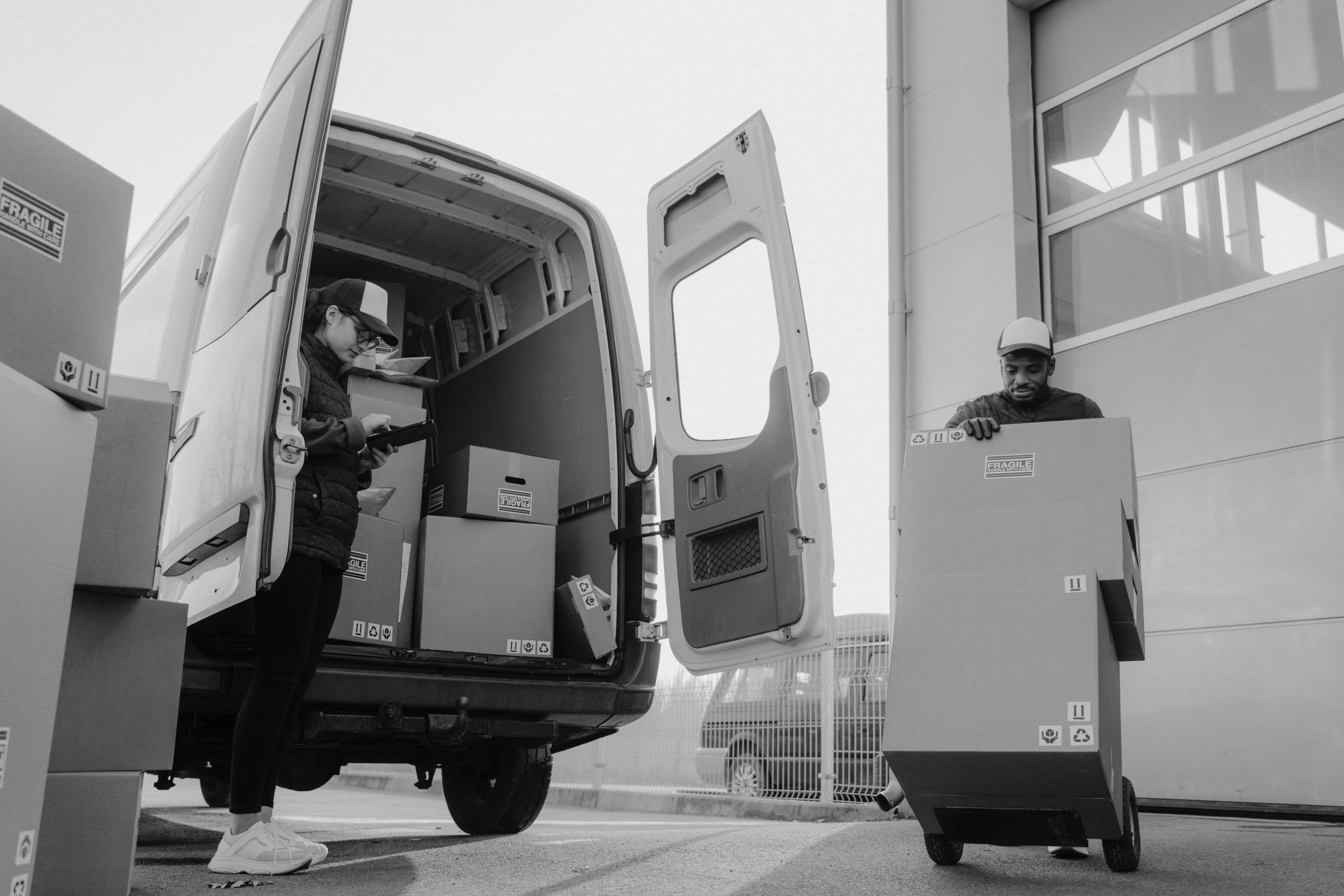 a man that is standing in the back of a van, a black and white photo, by Adam Marczyński, pexels contest winner, arbeitsrat für kunst, delivering parsel box, inspect in inventory image, animation, yoh yoshinori