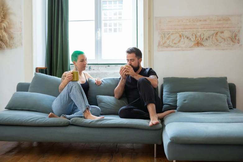 a man and a woman sitting on a couch, pexels contest winner, green corduroy pants, having a snack, millaise and greg rutkowski, apartment set in the near future