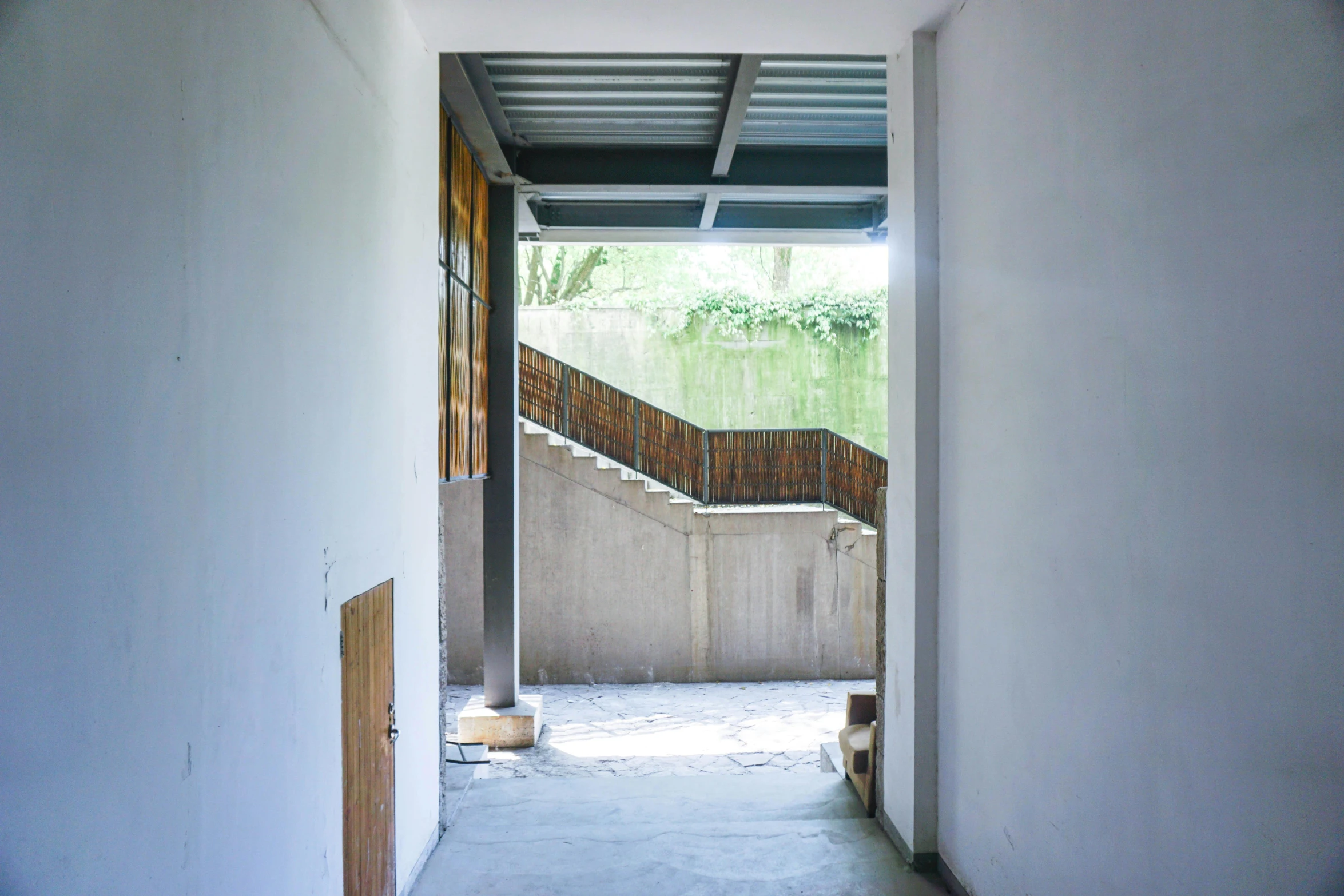 a door that is open in a room, inspired by Tadao Ando, unsplash, temporary art, outdoor staircase, construction site, white wall complex, school courtyard