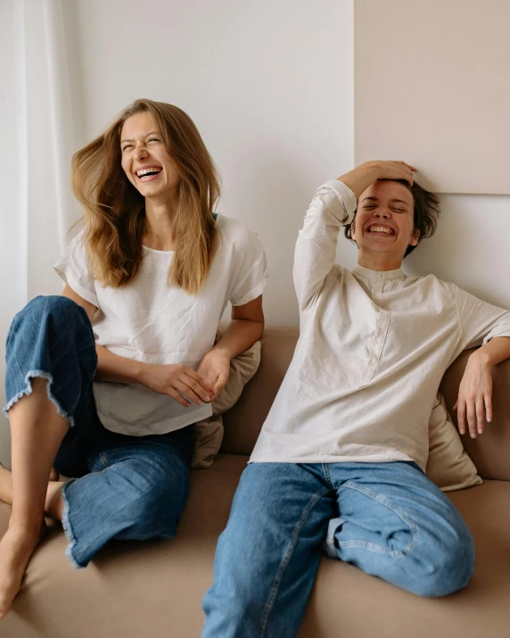 a couple of people that are sitting on a couch, trending on pexels, happening, lesbian, wearing a linen shirt, full of joy, model posing