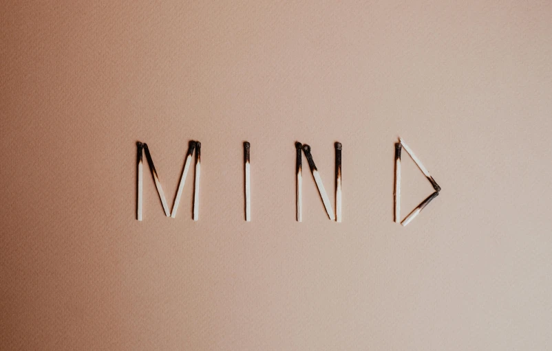 a close up of a metal object with the word mind written on it, an album cover, by Caroline Mytinger, trending on pexels, minimalism, thin spikes, background image, thinking pose, mental illness