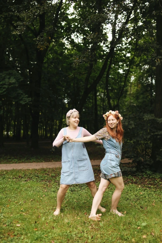 a couple of women standing on top of a lush green field, inspired by Elsa Beskow, pexels contest winner, renaissance, dancing a jig, forest punk, blue overalls, young redhead girl in motion