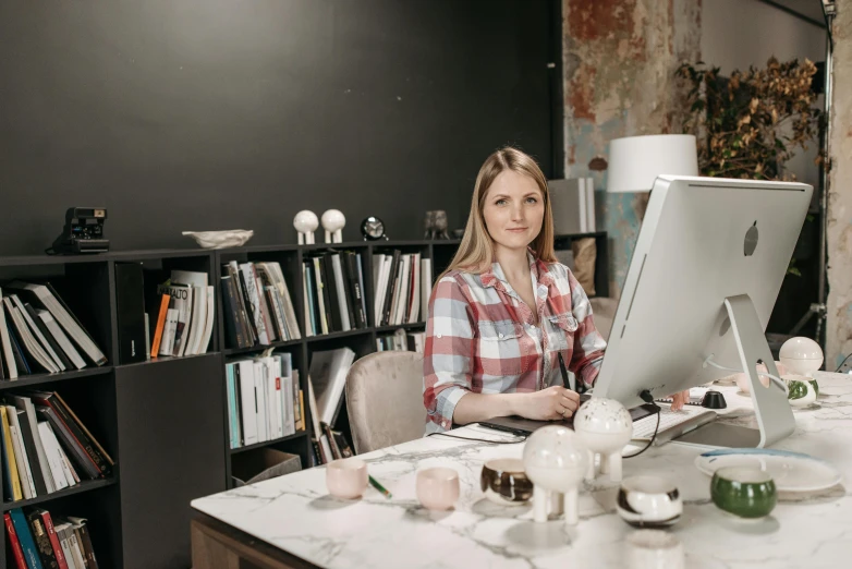 a woman sitting at a desk in front of a computer, a portrait, by Emma Andijewska, pexels contest winner, 9 9 designs, looking to camera, alexey gurylev, architect