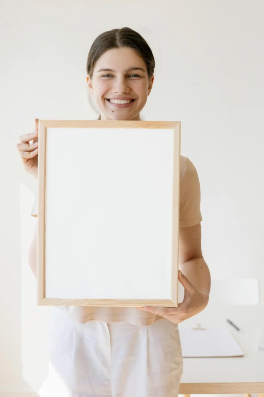 a woman holding a picture frame in front of her face, poster art, pexels contest winner, reference sheet white background, unfinished canvas, carrying a tray, large smile