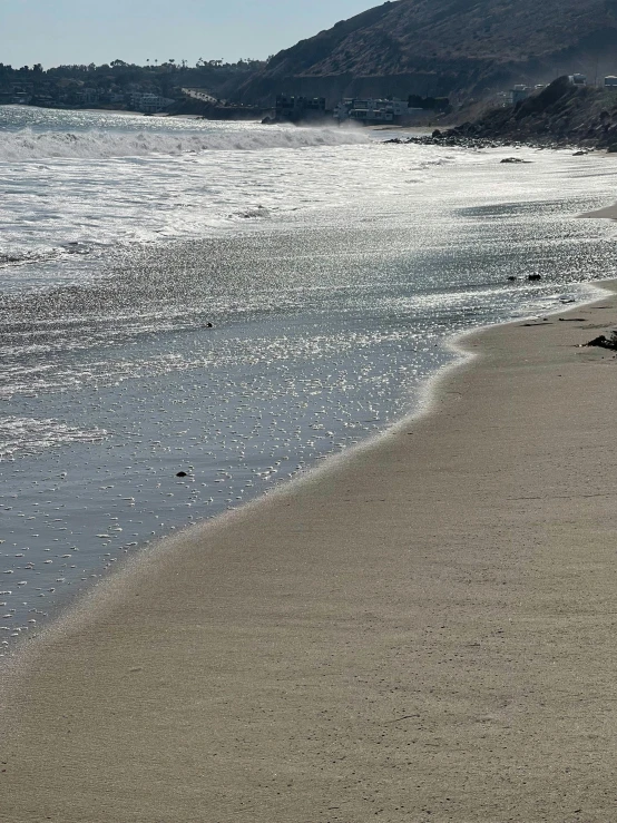 a person walking on a beach with a surfboard, 5 feet away, malibu canyon, zoomed in, grayish