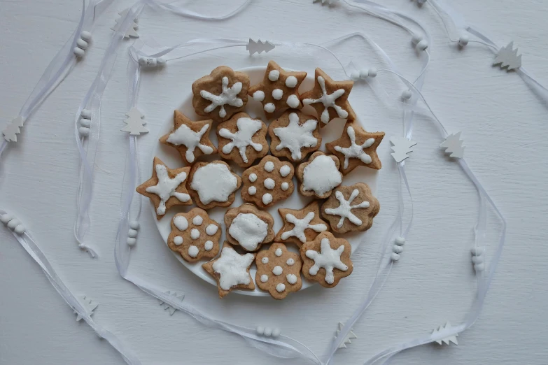 a plate that has some cookies on it, by Sylvia Wishart, unsplash, folk art, white stars in the background, white ribbon, white ceramic shapes, natural soft rim light