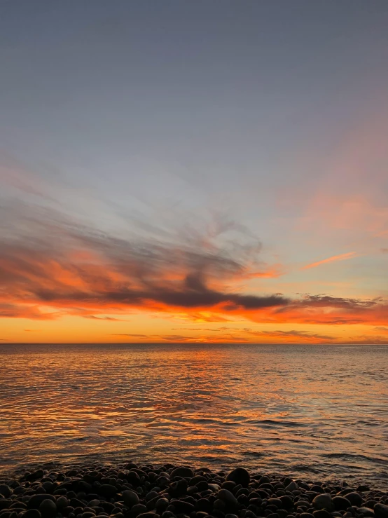 a sunset over a body of water with rocks in the foreground, ultrawide image, gradient red to yellow, photo of the middle of the ocean, today\'s featured photograph 4k