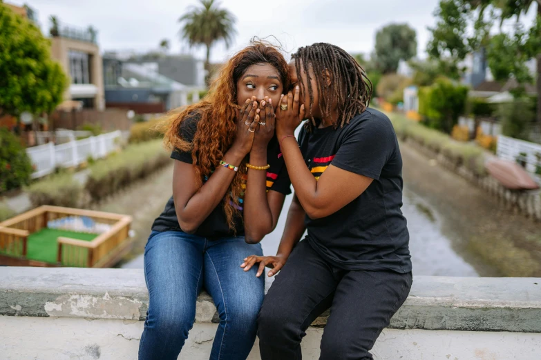 a couple of people sitting on top of a cement wall, pexels contest winner, happening, african facial features, lesbian, screeching, 15081959 21121991 01012000 4k