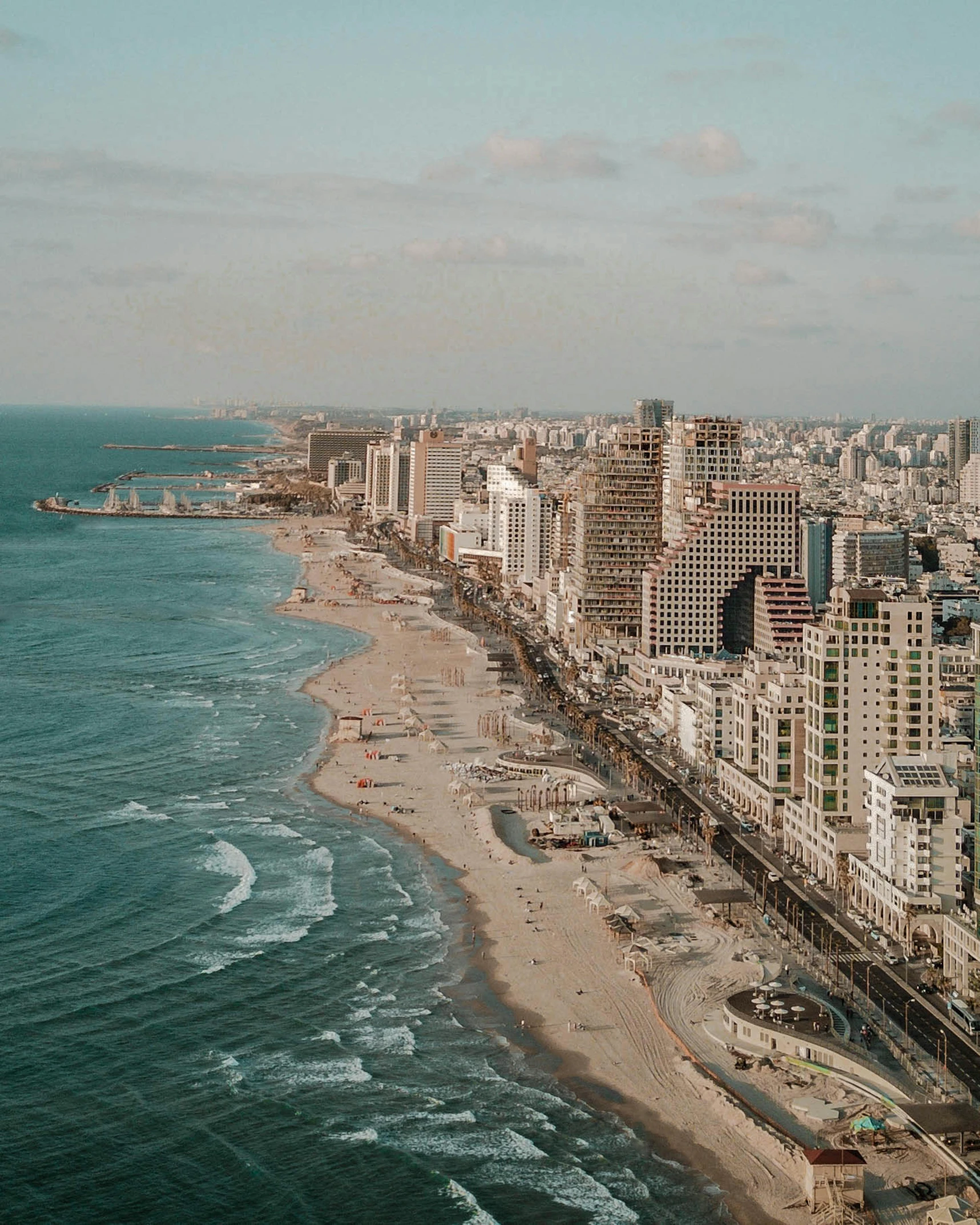 an aerial view of a city next to the ocean, a colorized photo, pexels contest winner, israel, lgbtq, hotel room, beach aesthetic