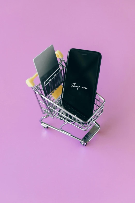 a mobile phone in a shopping cart on a pink background, a picture, pexels, pair of keycards on table, dark. no text, square, high quality photo