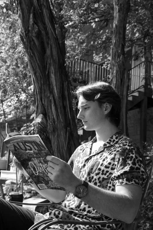 a woman sitting in a chair reading a book, a black and white photo, inspired by Ruth Orkin, realism, taken in silver dollar city, candid photo of gal gadot, sitting in a tree, reading a newspaper