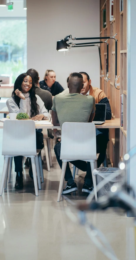 a group of people sitting around a table, by Carey Morris, pexels, in a open-space working space, alphonse muca, thumbnail, laura zalenga