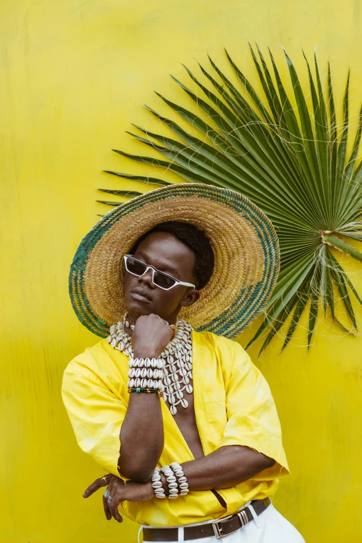 a woman standing in front of a yellow wall, trending on pexels, afrofuturism, brown skin man egyptian prince, tropical, wearing gold glasses, wearing sombrero