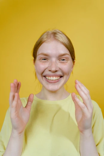 a young girl making a funny face with her hands, a character portrait, trending on pexels, yellow uneven teeth, nonbinary model, a blond, pale - skinned