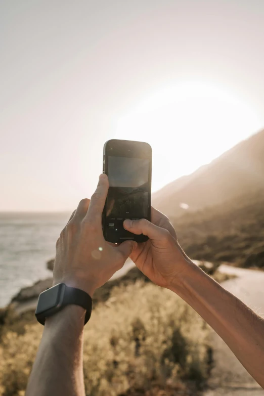 a person taking a picture with a cell phone, trending on unsplash, romanticism, on a cliff, trail camera, phone!! held up to visor, 6 : 3 0 am