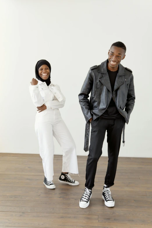 a couple of people that are standing in a room, inspired by Afewerk Tekle, trending on unsplash, hurufiyya, wearing a turtleneck and jacket, wearing white sneakers, black teenage boy, islamic