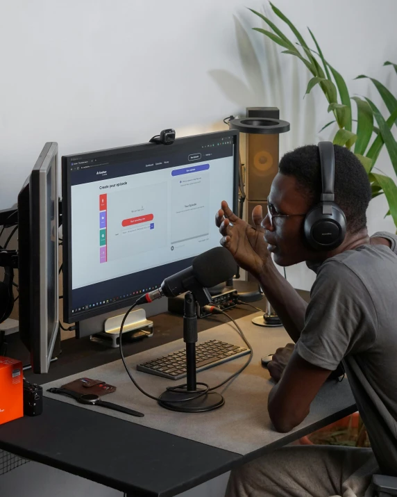 a man sitting at a desk in front of a computer, pexels contest winner, afrofuturism, standing microphones, lgbt, discord profile picture, ignant