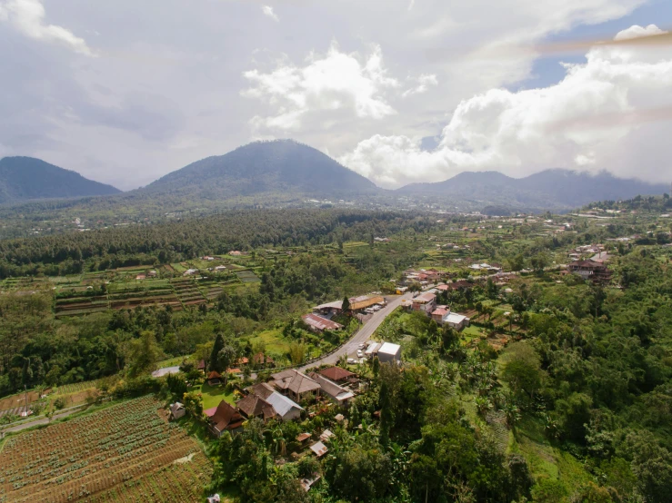 an aerial view of a village with mountains in the background, sumatraism, background image, lerapi