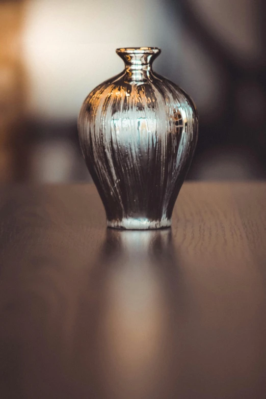 a glass vase sitting on top of a wooden table, by Adam Szentpétery, unsplash, silver ornaments, oil glaze, indoor smooth light, perfume