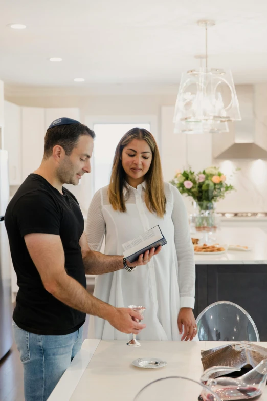 a man and a woman standing in a kitchen, zillow interior, middle eastern style vendors, scanning items with smartphone, hebrew