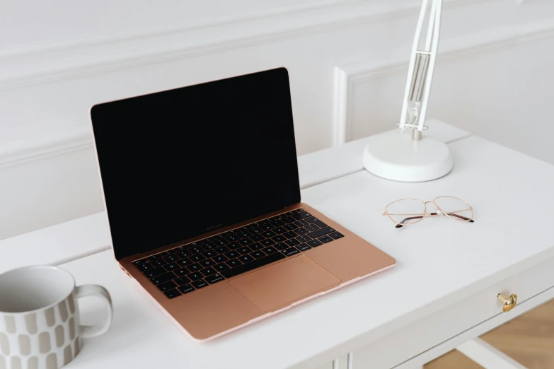 a laptop computer sitting on top of a white desk, by Julia Pishtar, trending on pexels, copper, brown, console, thumbnail