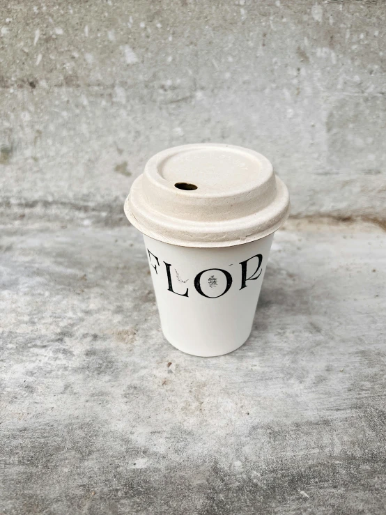 a coffee cup sitting on top of a cement floor, by Felicity Charlton, top lid, floro details, simple logo, oops