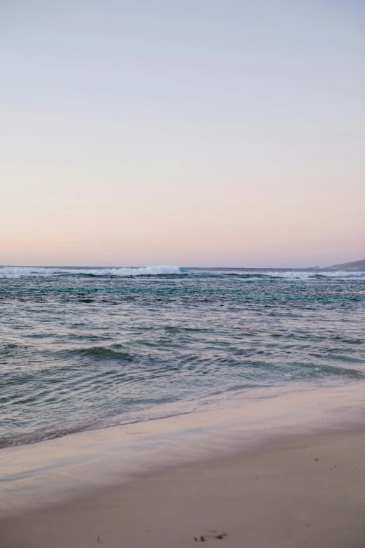 a man riding a surfboard on top of a sandy beach, unsplash, minimalism, evening at dusk, south african coast, wide long view, viewed from the ocean