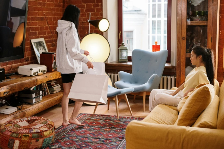 a woman standing in a living room holding a bag, by Julia Pishtar, pexels contest winner, furniture around, people shopping, rugs, wearing a white robe