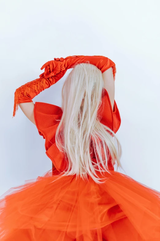 a woman with long blonde hair wearing an orange dress, an album cover, unsplash, rococo, bright white hair, red gloves, hands in her hair. side-view, vera wang couture
