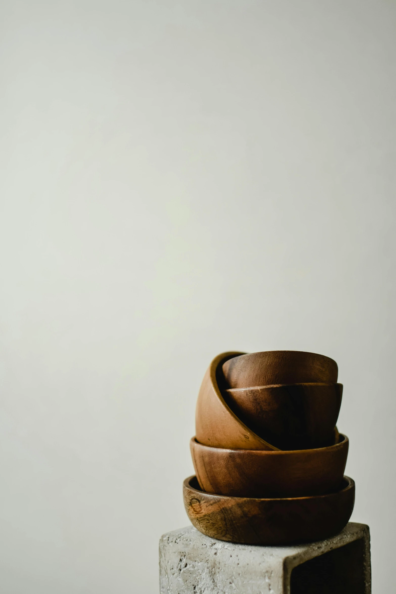 a stack of wooden bowls sitting on top of a cement block, trending on unsplash, renaissance, chocolate frosting, portrait n - 9, leather, minimalist photo