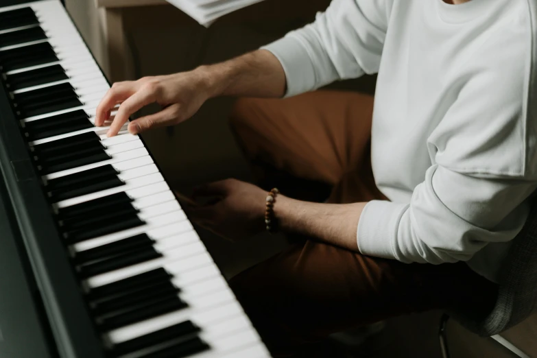 a close up of a person playing a piano, an album cover, trending on pexels, wearing a white button up shirt, avatar image, professional image, extremely high resolution