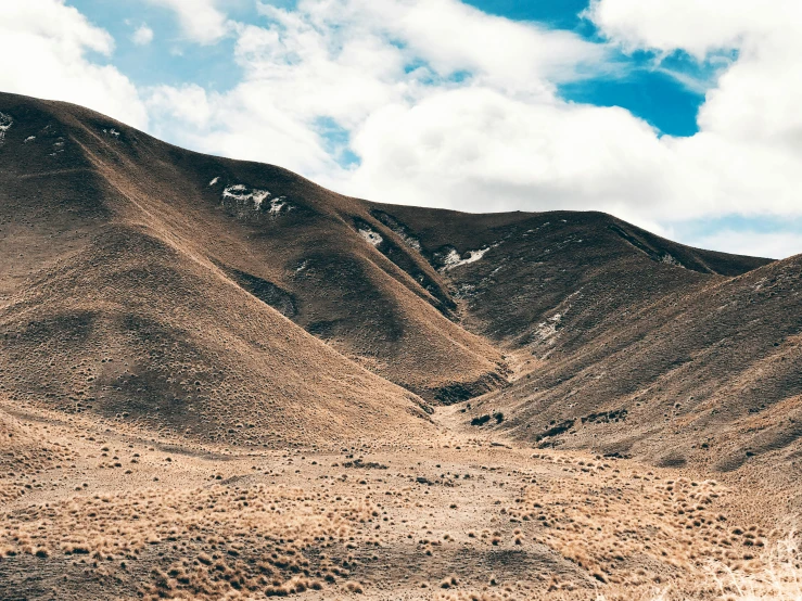 a man riding a motorcycle down a dirt road, trending on unsplash, les nabis, looking down at a massive crater, new zealand landscape, background image, old photo of a creepy landscape