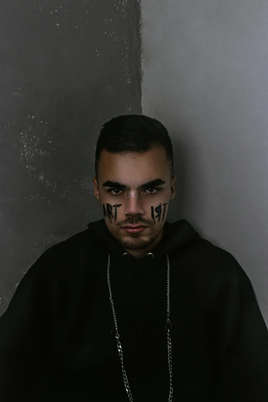 a man with a cross painted on his face, an album cover, trending on pexels, antipodeans, he is wearing a black, frown, asher duran, lgbt