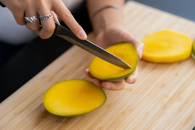 a person cutting a mango on a cutting board, inspired by Kanō Tan'yū, trending on pexels, australian, plating, 🦩🪐🐞👩🏻🦳, round-cropped