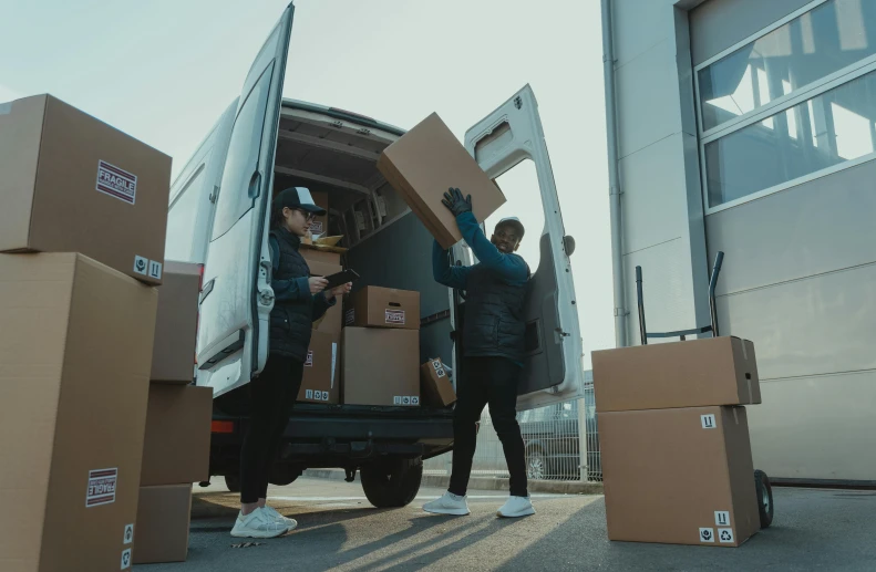 two men unloading boxes into the back of a van, pexels contest winner, renaissance, brown, small, centralised, low quality photo