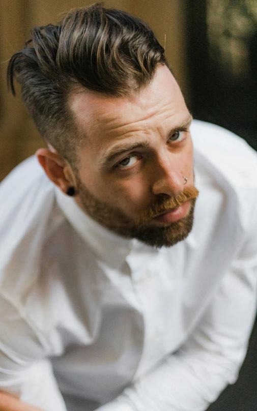 a man with a beard wearing a white shirt, an album cover, inspired by Tomàs Barceló, unsplash, hyperrealism, rockabilly hair, groom, tiny thin mustache, androgynous person