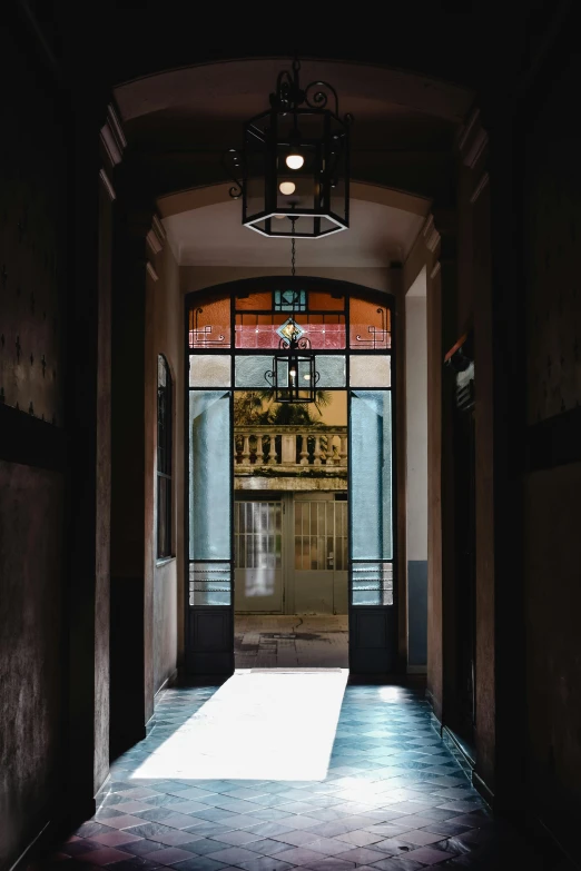 a hallway with a light at the end of it, inspired by Luis Paret y Alcazar, art nouveau, view from the streets, door to lab, taken in the early 2020s, inside a grand