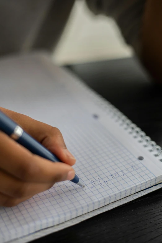 a person writing on a notebook with a pen, mathematics unifying science, thumbnail, taken with sony alpha 9, student