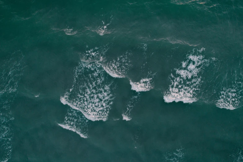 a group of surfers riding waves in the ocean, an album cover, inspired by Elsa Bleda, pexels, renaissance, satellite view, dark green water, subtle pattern, thumbnail