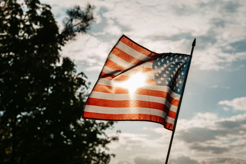 an american flag blowing in the wind on a sunny day, a picture, by Carey Morris, pexels, evening lighting, 🚿🗝📝