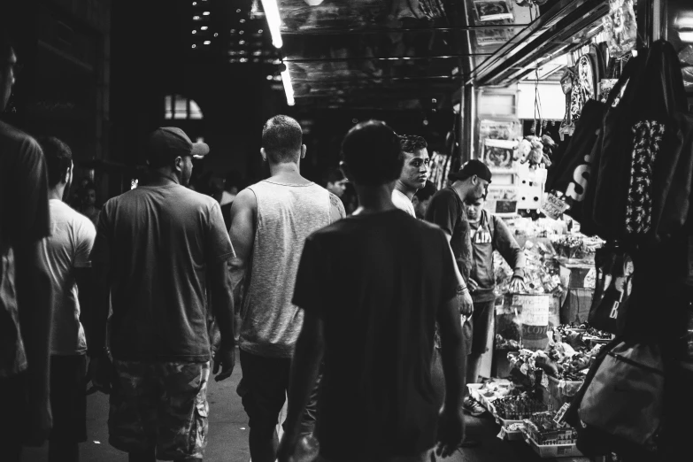 a group of people walking through a market, a black and white photo, pexels, guys, dark people discussing, music video, facebook photo