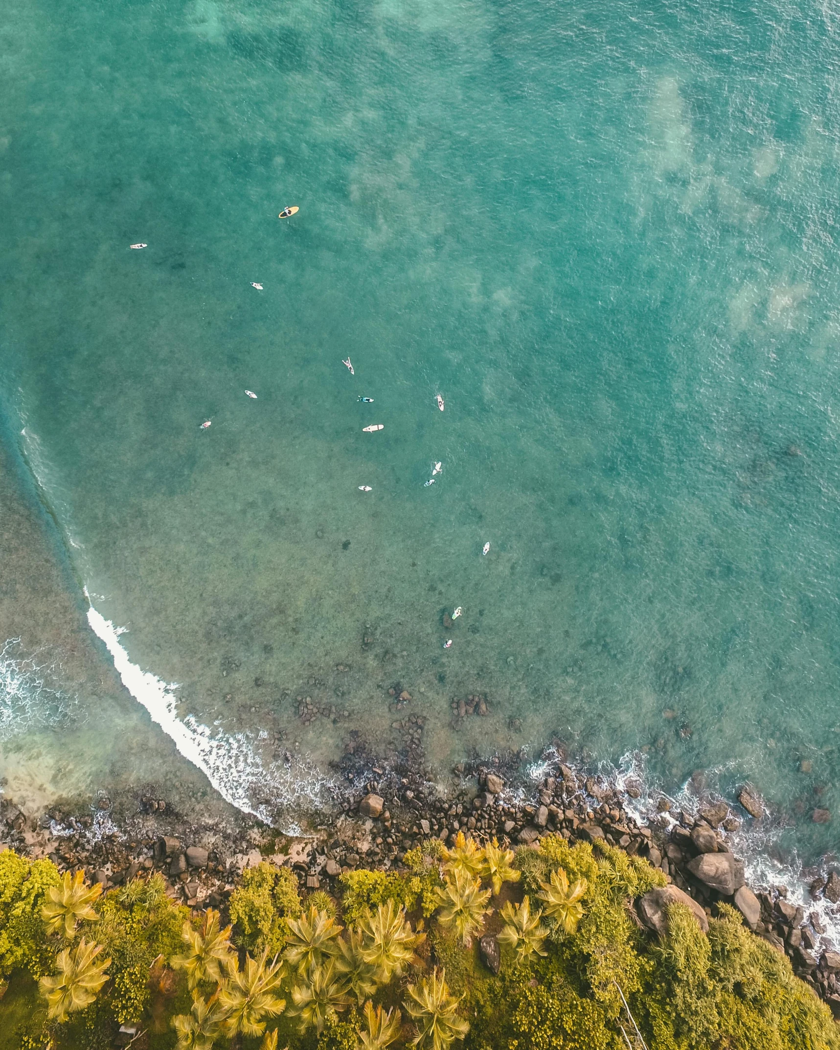 an aerial view of a beach and a body of water, a screenshot, pexels contest winner, happening, standing on surfboards, reunion island, thumbnail, multiple stories