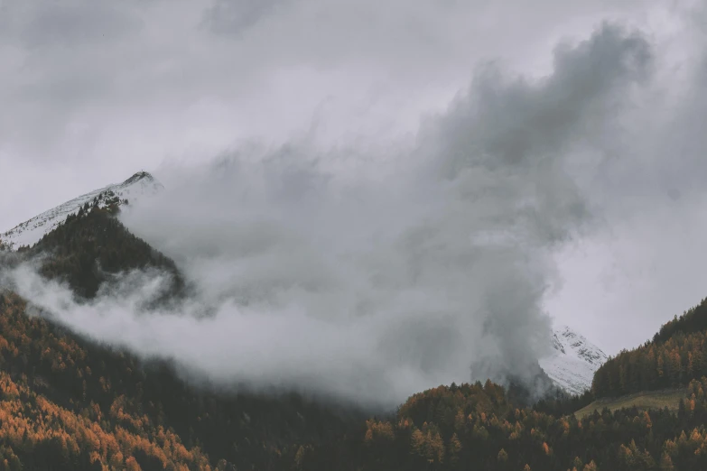 a mountain covered in lots of trees under a cloudy sky, by Karl Buesgen, pexels contest winner, romanticism, grey, music video, 4 k hd wallpapear, storm outside