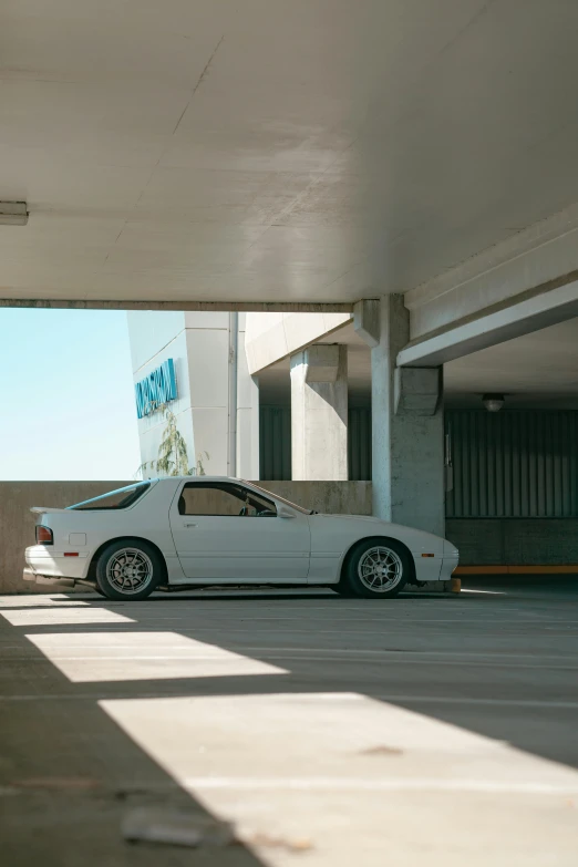 a white car parked in a parking garage, a photo, inspired by Hiroshi Honda, unsplash, iroc, ignant, in a las vegas street, cinestill 800t eastmancolor